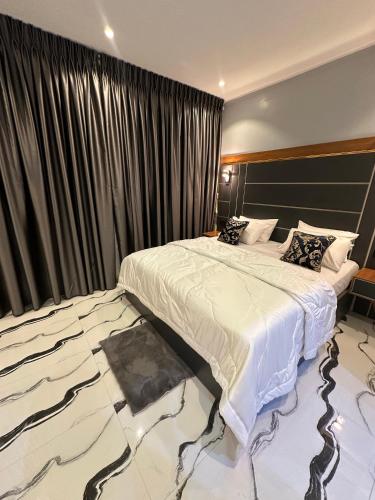a bedroom with a large bed and a large window at Apartment 5 in Abuja