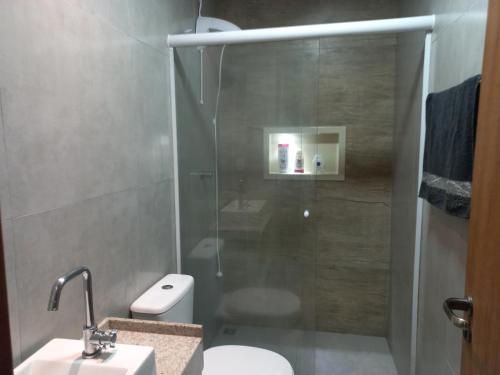 a bathroom with a shower with a toilet and a sink at Caso 3 in São José