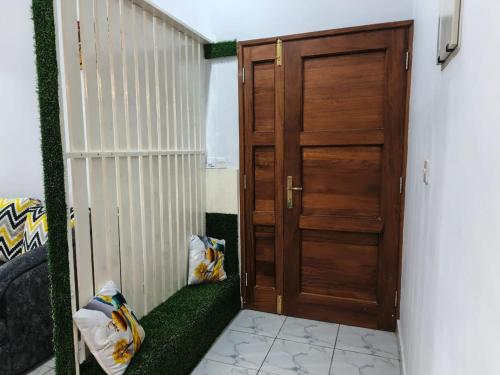 a room with a wooden door and a green carpet at Blessing homes in Mombasa