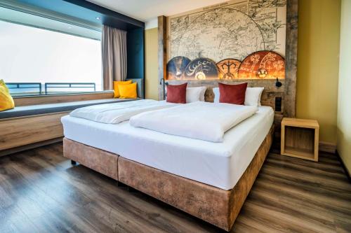 a bedroom with a large bed with a map on the wall at Ostseehotel Midgard in Damp in Damp