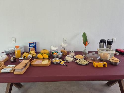 a table with many different types of food on it at Pousada Janela dos Ventos in Caucaia