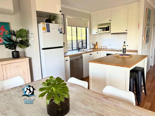 a kitchen with a table and a white refrigerator at Lake & Reserve Front Bird Haven - 3BR in Encounter Bay