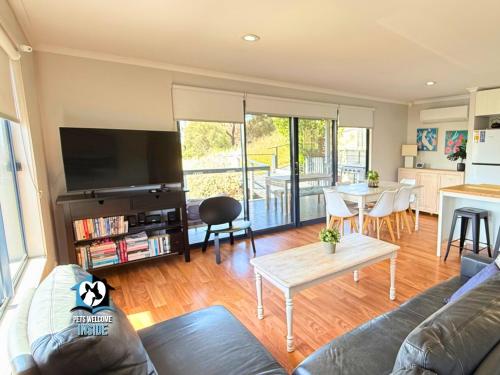 Lake & Reserve Front Bird Haven - 3BR في Encounter Bay: غرفة معيشة مع أريكة وطاولة