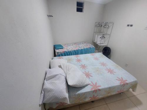 a small room with a bed and a crib at Casa de Arembepe in Camaçari