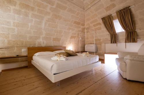 a bedroom with a bed in a stone wall at Antica Dimora storica La finestra sul campanile in Matera