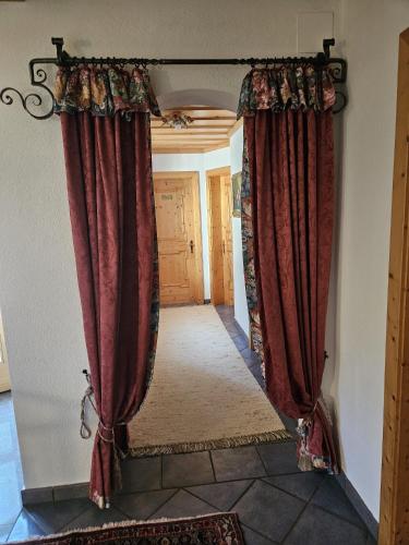 an open doorway with red curtains in a hallway at Bauernhof Tuxerschafer in Tux