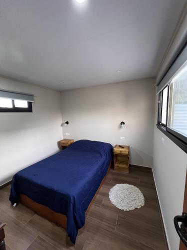 a bedroom with a blue bed and a window at Hospedaje a 2 cuadras del mar Mar de Cobo 4 personas in Mar de Cobo