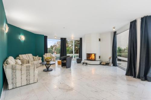 een woonkamer met banken en een open haard bij Black Dragon Haven Villa with Pool Sauna Jacuzzi BBQ & Parking for 8 Cars in Praag