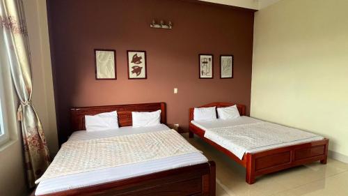 高平Hòa An Hotel- motorbike rental的小客房内的两张床,配有两张sidx sidx单人床