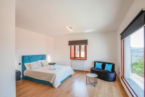 a bedroom with a bed and a chair at Mirando Espanha in Melgaço