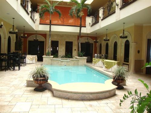 a swimming pool in a building with a restaurant at Hotel Gran Mediterraneo in San Pedro Sula