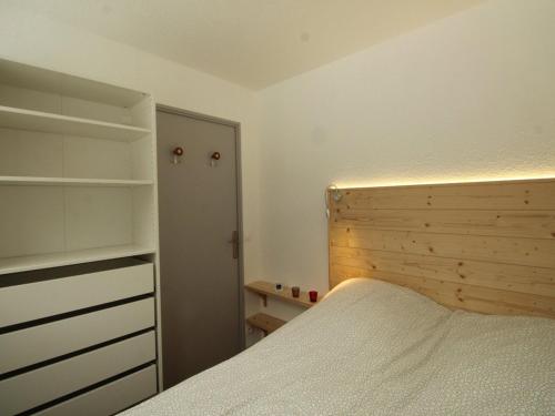 a bedroom with a bed and a wooden headboard at Appartement rénové 3 pièces - 6 pers - Balcon Sud - Résidence Sirius à Flaine Forêt - FR-1-687-5 in Arâches-la-Frasse