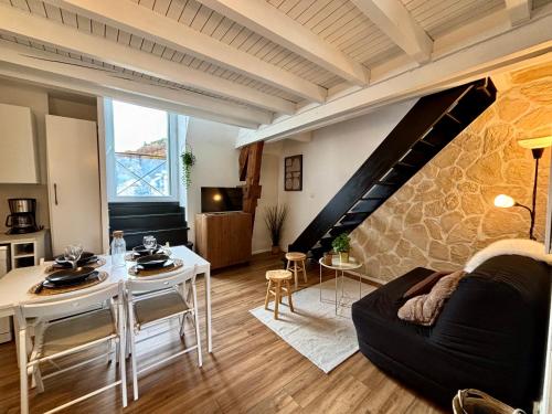 a living room with a black couch and a table at Le 41 - Cosy et Confort in Barèges