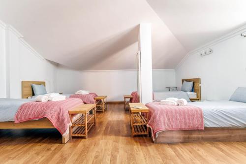 two beds in a room with wooden floors at Bright 3-BR in Guia with Shared Pool by Lisbeyond in Guia