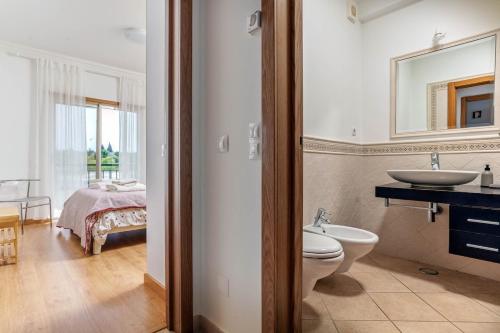 a bathroom with a toilet and a sink and a bed at Bright 3-BR in Guia with Shared Pool by Lisbeyond in Guia