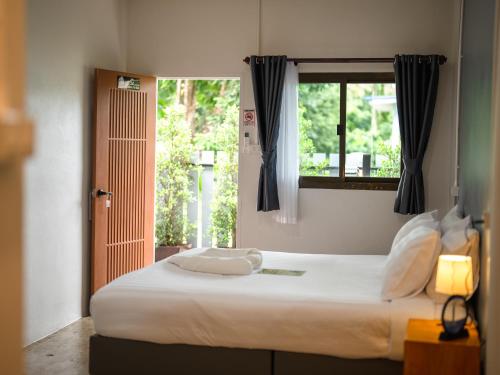 a bedroom with a large white bed with a window at Fix 25 House Koh Kood in Ban Khlong Mat