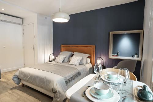 una camera con letto e tavolo con bicchieri da vino di Le studio Belledonne de Paradis a Chambéry