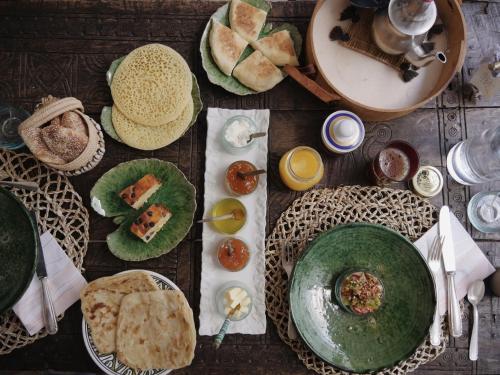 een houten tafel met borden met eten erop bij Riad La Lumière d'Étoile in Marrakesh