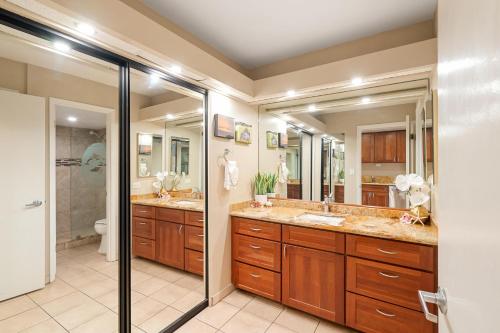 a bathroom with two sinks and two mirrors at Eldorado A108 in Kaanapali