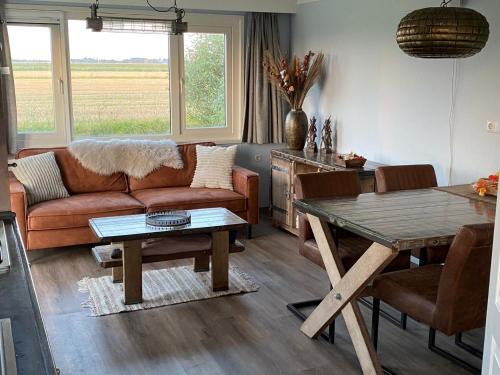 un salon avec un canapé et une table dans l'établissement 't Skagerwad, à Oudesluis
