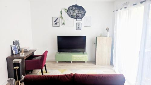 Una sala de estar con un sofá y un televisor. en Cocon Colombes - close to La Défense and Paris, en Colombes
