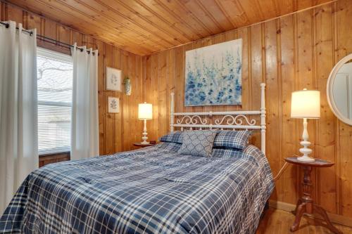 a bedroom with a bed with a blue plaid blanket at Wine Country Retreat with Fire Pit and Sunroom! in Dahlonega