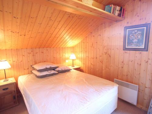 a bedroom with a bed with pillows on it at Chalet confortable avec billard, cheminée et Wifi à Vallandry - FR-1-411-545 in Landry