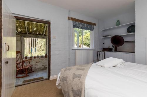 a bedroom with a bed and a chair and a window at Large family home based at Westerlands Farm in Graffham