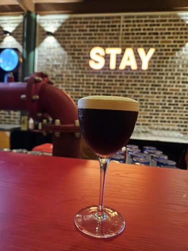 a glass of wine sitting on top of a table at Stay HostelandBar in Làng Cac