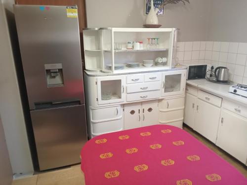 a kitchen with a refrigerator and a red rug at 63 On Main in Zuurbraak