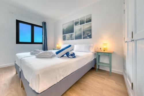 een witte slaapkamer met een bed en een tafel bij Casa Ondina in Puerto del Carmen