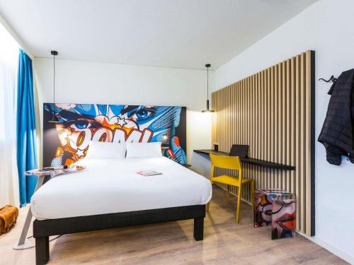- une chambre avec un lit et un bureau avec une chaise jaune dans l'établissement ibis Styles Bordeaux Sud, à Villenave-dʼOrnon