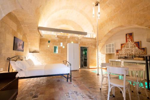 ein Schlafzimmer mit einem Bett, einem Tisch und Stühlen in der Unterkunft LUX LUCIS in Matera