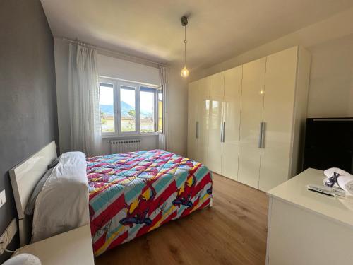 een slaapkamer met een bed met een kleurrijk dekbed bij Forato Holiday Appartament in Marina di Pietrasanta