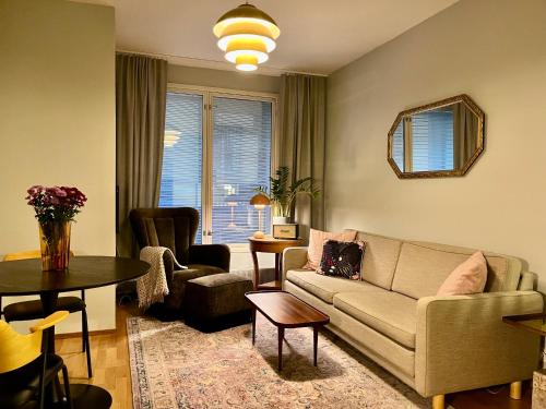 un soggiorno con un divano e un tavolo di Luotsi 1911 Suite a Helsinki