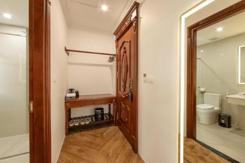 富国Emirates Hotel Phu Quoc的一间带木门和卫生间的浴室