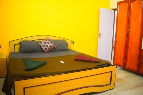 een gele slaapkamer met een bed met kussens erop bij Sharmila residency in Mahabalipuram
