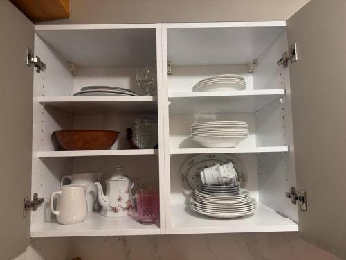 a white cabinet with plates and dishes in it at Apartaments Eischoll in Arni Alp