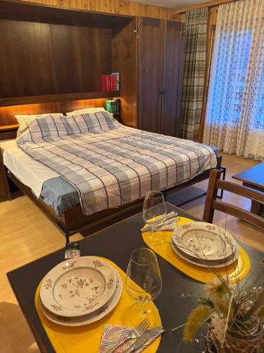 a bedroom with a bed and two tables with plates and glasses at Apartaments Eischoll in Arni Alp