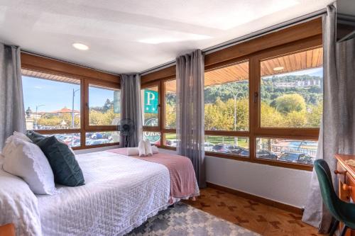 a bedroom with a bed and a large window at EMAROOMS Laredo in Laredo