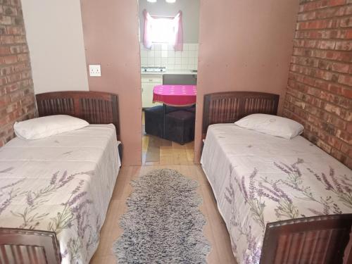 a room with two beds and a pink table at 63 On Main in Zuurbraak