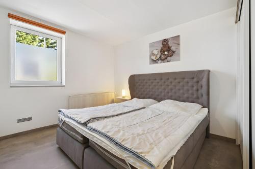a bed in a bedroom with a window at Ferienwohnung "Zum Segel" 2 in Zadelsdorf