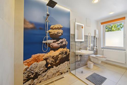 a bathroom with a wall mural of a rock formation at Ferienwohnung "Zum Segel" 2 in Zadelsdorf