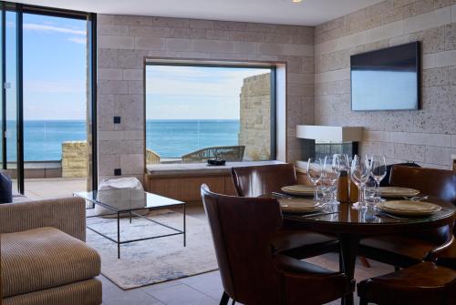 a dining room with a table and a view of the ocean at Clifftops - Blue Lodge in Portland