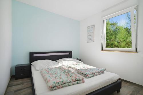 a bed in a white room with a window at Ferienhaus 110 in Stelzendorf
