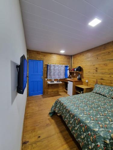 a bedroom with a bed and a blue door at Cedro Rosa in Guarapari