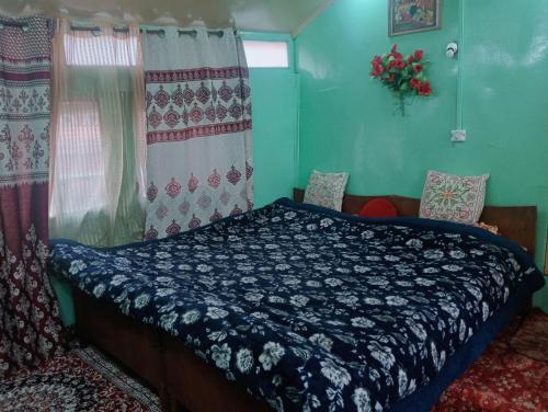 a bedroom with a bed with a blue comforter at Holiday Home in Srinagar