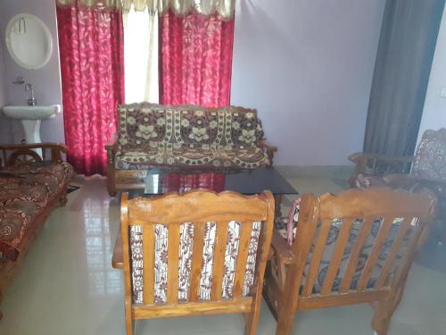 a living room with two chairs and a couch at Wood stone step in Napoklu