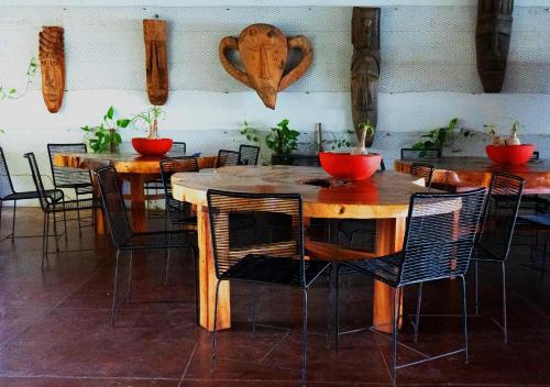 una sala da pranzo con tavoli e sedie con piante sul muro di Tribu Tipis & Surf a Puerto Escondido