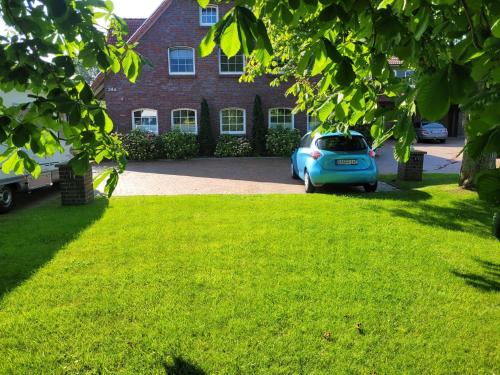 a blue car parked in front of a house at Ferienhaus Landskron in Wangerland